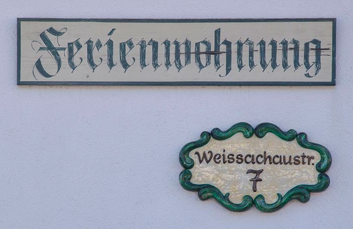 Handgemalte Schilder am Haus: „Ferienwohnung“ und „Weissachaustr. 7“